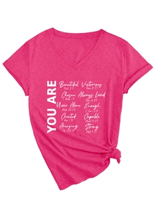 Détail du t-shirt col V rose fuchsia avec manches retroussées et texte inspirant