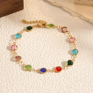 Dettaglio di bracciale dorato con pietre in zirconia multicolore e chiusura a moschettone