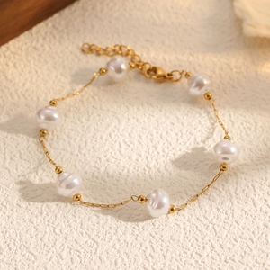Détail du bracelet en perles baroques dorées avec chaîne d'extension et fermoir mousqueton