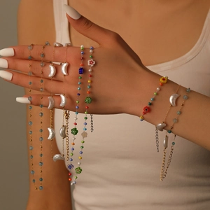 Elegant moon pendant pearl necklace and layered beaded jewelry worn by a female model