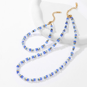 Rainbow crystal bead necklace and bracelet set with gold accents on white stand