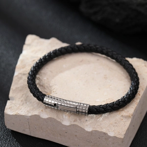 Classic men's black braided leather bracelet with textured stainless steel clasp on stone
