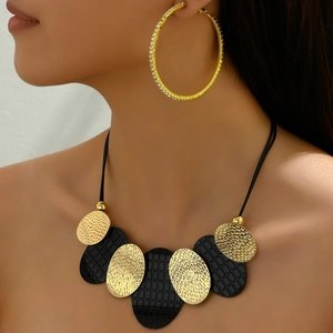 Chic black and hammered gold oval link necklace set with large crystal hoop earrings