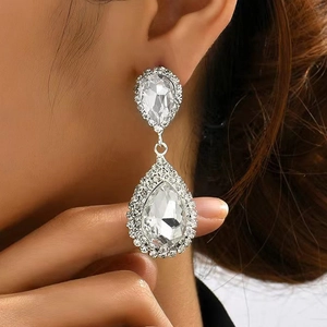 Elegant silver teardrop earrings with sparkling crystals shown on a model side profile