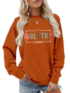 Close-up of bright orange Girls Trip 2024 sweatshirt with leopard heart graphic print