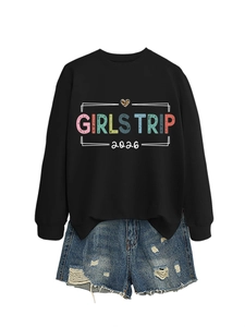 Flat lay of a black Girls Trip 2026 sweatshirt paired with distressed blue denim shorts