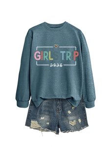 Detail of grey blue sweatshirt with Girls Trip 2026 print and distressed denim shorts