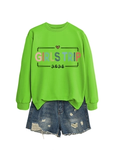 Detail of Girls Trip 2026 sweatshirt with neon green fabric and distressed denim shorts