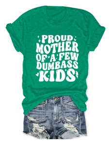 Dettaglio della t-shirt verde in cotone con stampa bianca e shorts in denim usurati