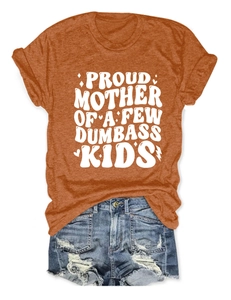 Flat lay della t-shirt arancione Proud Mother con pantaloncini di jeans strappati su bianco