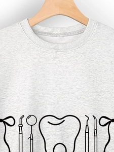 Close-up of crewneck tee featuring dental tool graphics and tooth print on soft fabric