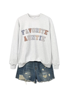 Dettaglio felpa grigia a maniche lunghe con scritta Favorite Auntie e shorts in denim