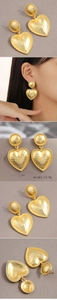 Detailed view of large gold heart drop earrings with hammered texture and rope edge