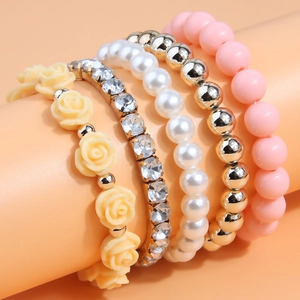 Five-piece multi-layered beaded bracelet set with flower charms and crystals on a display