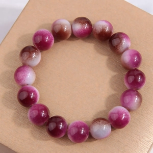 Fashionable gradient beaded bracelet with purple and white beads on a wood surface
