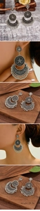Bohemian silver earrings with floral carving and tassel fringe details on a natural background