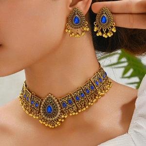 Ethnic peacock necklace set with blue gems and antique gold finish on model