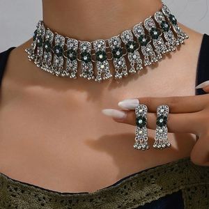 Detail of vintage boho choker and earring set with green gems and silver metallic drapes