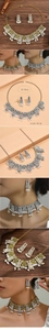 Détail d'une parure de bijoux boho avec motifs de fleurs ajourées et perles blanches