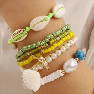 Macro detail of Bohemian multilayer bracelet set with starfish and seashell charms