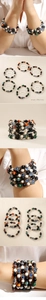 Détail de bracelets bohèmes multicouches avec cœur, main de Hamsa et œil bleu
