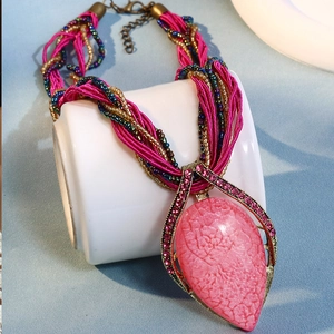 Détail du pendentif goutte rose bohème avec texture marbre et chaîne à perles tissées