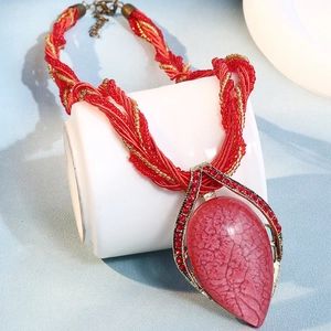 Vue détaillée du collier bohème avec pierre rose en goutte et cristaux rouges fins