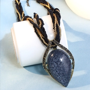 Détail du collier bohème avec pendentif goutte gris craquelé et cordon tressé