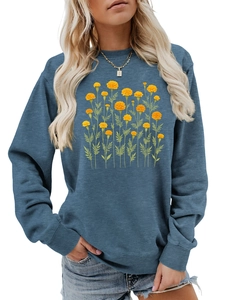 Dettaglio della stampa floreale con calendule gialle su una felpa blu a maniche lunghe