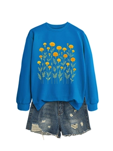 Dettaglio felpa blu con stampa calendula gialla e pantaloncini di jeans strappati vintage