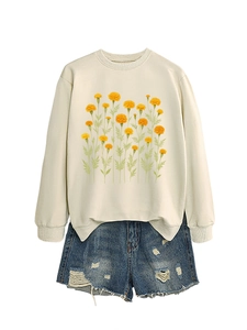 Felpa da donna color crema con stampa di calendula e pantaloncini di jeans strappati