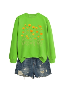 Dettaglio della stampa floreale calendula su felpa verde acceso e pantaloncini denim
