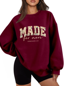 Detail of burgundy sweatshirt featuring floral MADE for more EPHESIANS text art