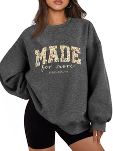 Detail of dark gray oversized hoodie featuring floral MADE lettering and Ephesians text
