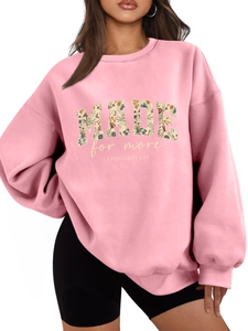 Detail of pink crewneck sweatshirt featuring floral Made for More chest print design