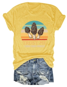 Flat lay of yellow t-shirt with mushroom pun design and distressed denim shorts