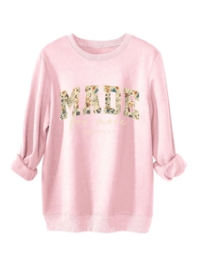 Detail of floral-filled 'MADE' text print on pink fleece sweatshirt with ribbed collar