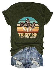 Flat lay of forest green t-shirt with mushroom print and distressed blue denim shorts