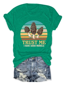 Flat lay of green cotton T-shirt featuring a mushroom graphic and humorous typography
