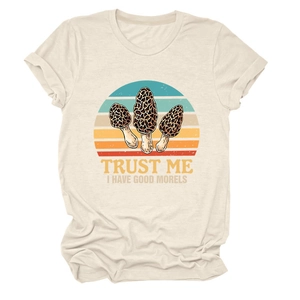 Close-up of beige t-shirt with mushroom graphic and Trust Me I Have Good Morels slogan
