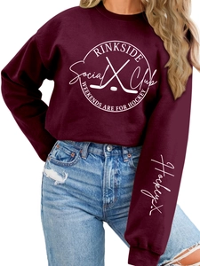 Close-up of Rinkside Social Club hockey print on burgundy fleece sweatshirt