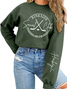 Detail of hockey themed graphics and sleeve embroidery on dark green oversized sweatshirt