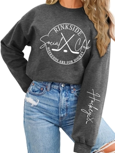 Close-up of Rinkside Social Club hockey print on a dark gray fleece sweatshirt