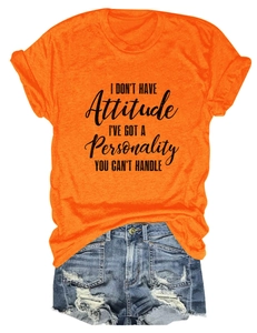 Detail of orange crewneck T-shirt with black slogan print and distressed denim shorts