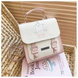 Sac à dos rose et crème sur chaise tressée montrant chiot mignon et boucles décoratives