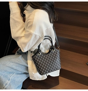 Détail du sac cabas vintage avec motif monogramme gris et anneaux métalliques dorés