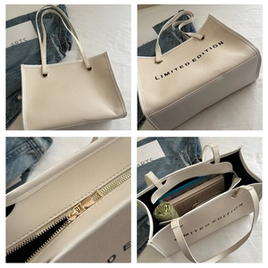 Detail view of large beige canvas tote bag with metal zipper and spacious interior