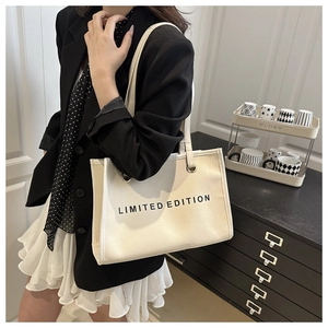 Detail view of large canvas tote bag with black Limited Edition print and shoulder strap
