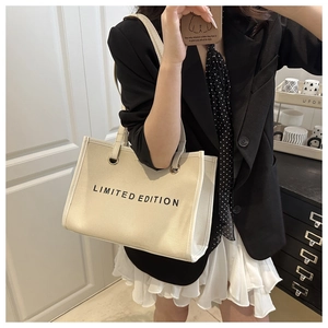 Close-up of beige canvas tote bag with Limited Edition print and shoulder strap detail