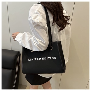 Detail of black leather tote bag with Limited Edition print and gold eyelet accents